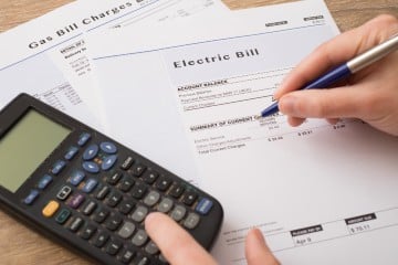 Electric bill charges paper form on the table with a calculator