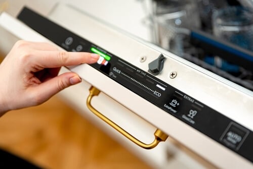 Person choosing eco mode on dishwasher