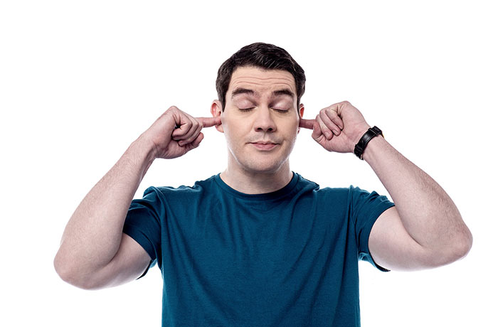 Man with fingers in ears