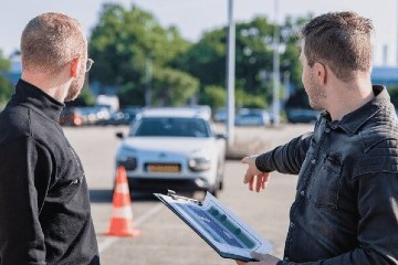 Image of two men looking at a vehicle that’s parked incorrectly in a parking bay
