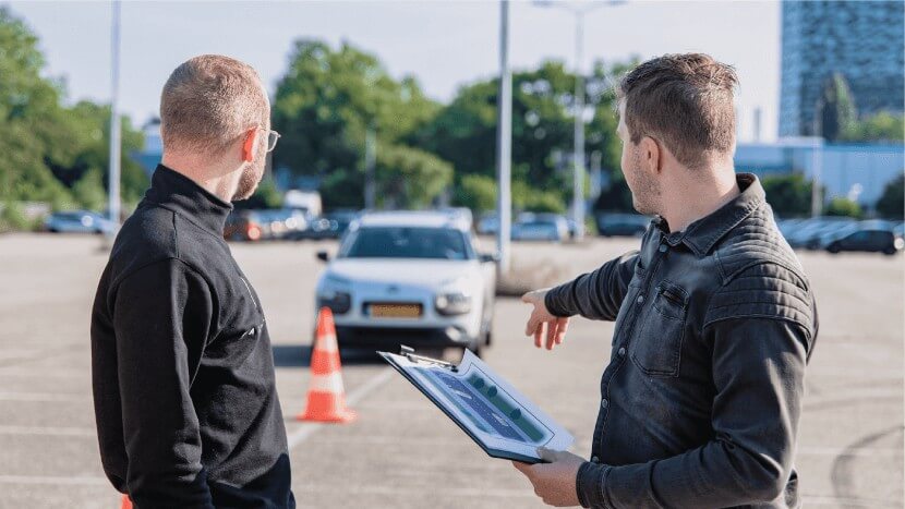 Image of two men looking at a vehicle that’s parked incorrectly in a parking bay