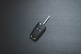 A black car key on a black surface