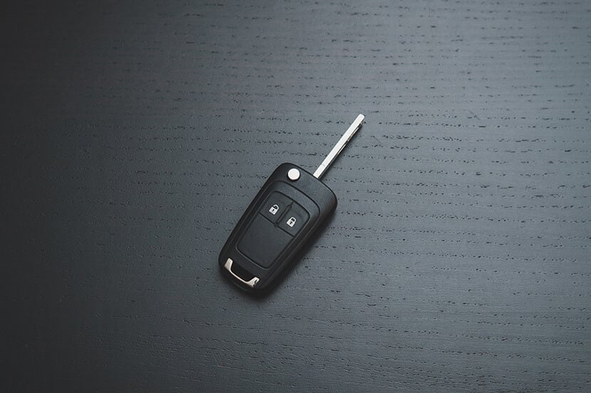 A black car key on a black surface