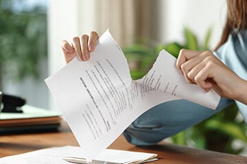 a person ripping up a piece of paper