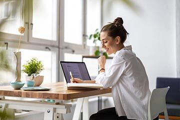 a lady working at a desk on a laptop