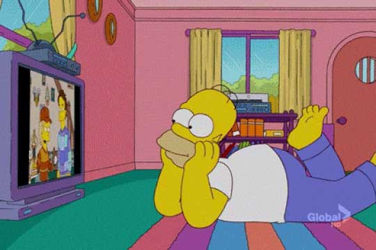 Homer Simpson lying on the floor watching the TV
