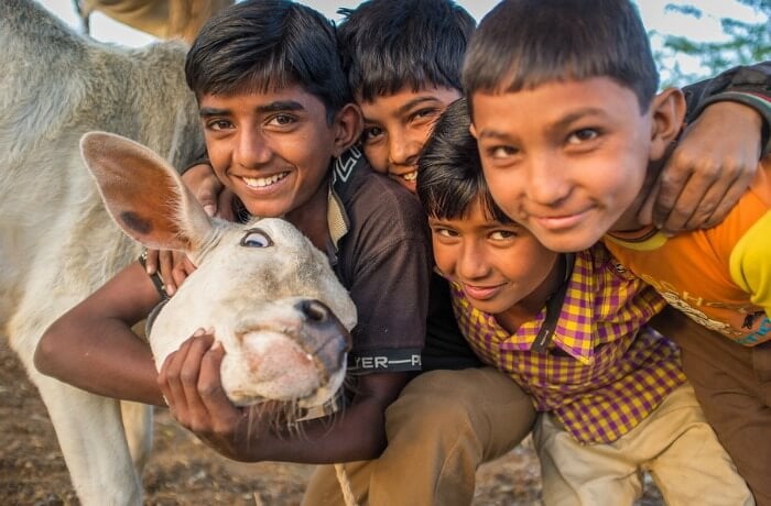 A group of Indian kids with a goat