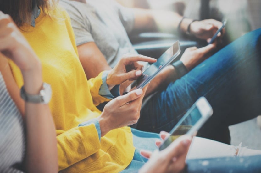 A group of people sitting down using their mobile phones