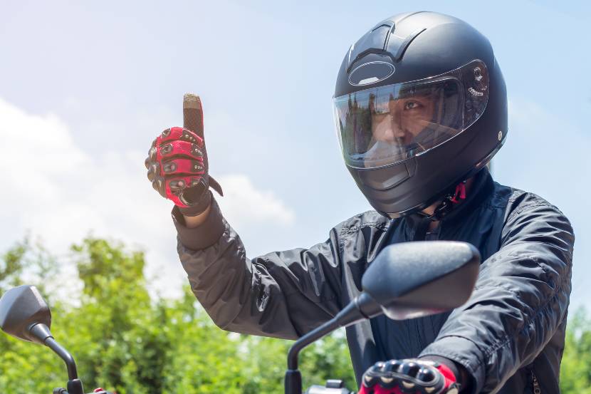 Biker with helmet giving the thumbs up