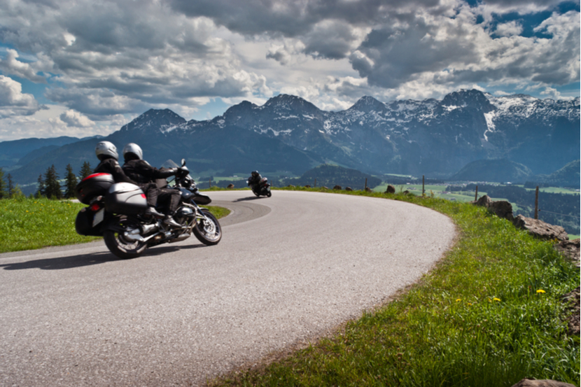 Motorbikes on the road in mountains with Alps in background