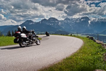 Motorbikes on the road in mountains with Alps in background