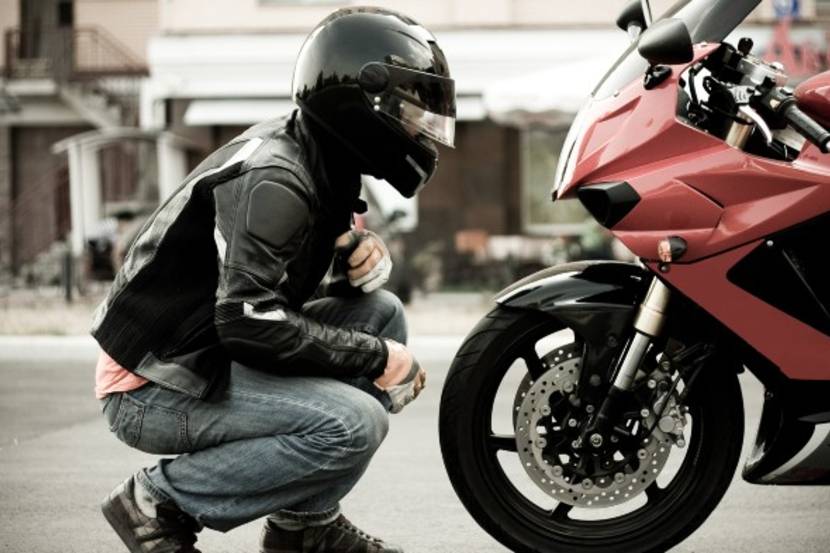 Motorcyclist looking at bike