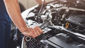Man looking inside car engine 