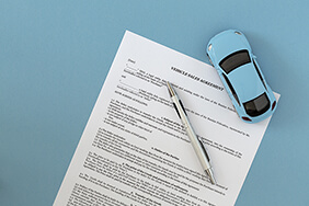 model car on top of a sales agreement