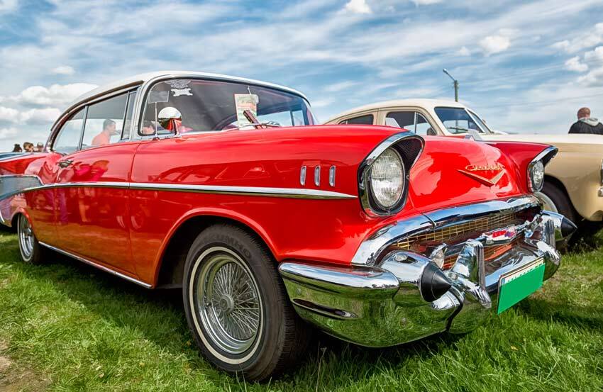 A classic, red American car park on grass at a car show