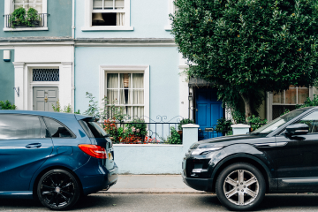 Two cars parked in front of a house