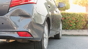 A car with a dent in the rear bumper caused by an untraceable driver