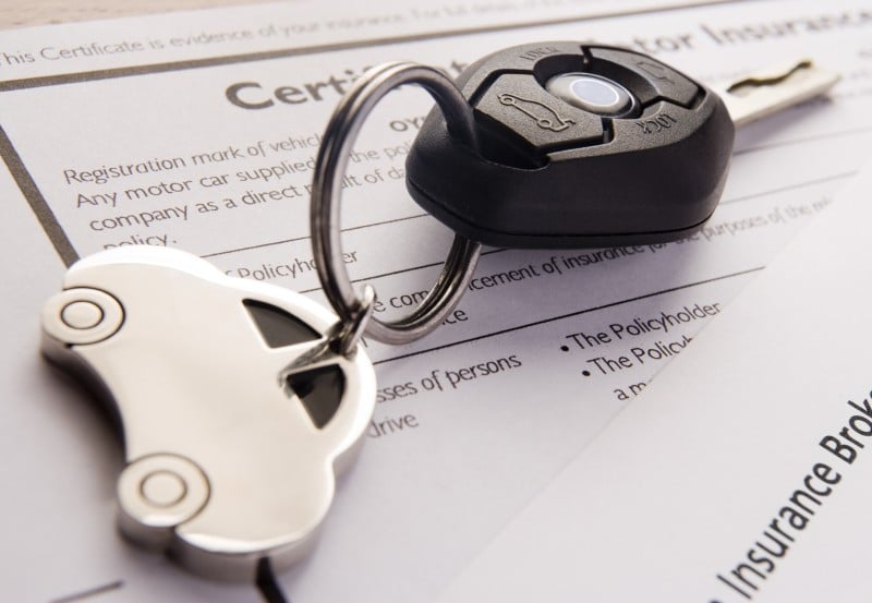 Car keys on top of car insurance documents