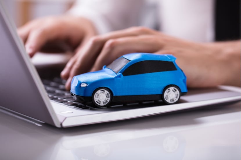 A model toy car sits on a laptop as user searches for car insurance 