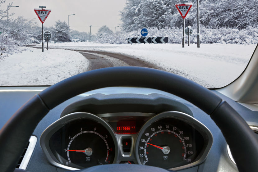 View of a driver's car dashboard driving through the snow