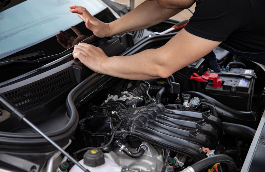 Close up image of mechanic servicing a car