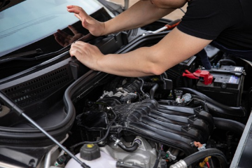 Close up image of mechanic servicing a car