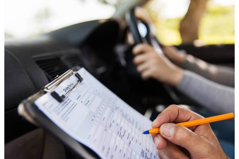 An instructor marks their student during a driving test