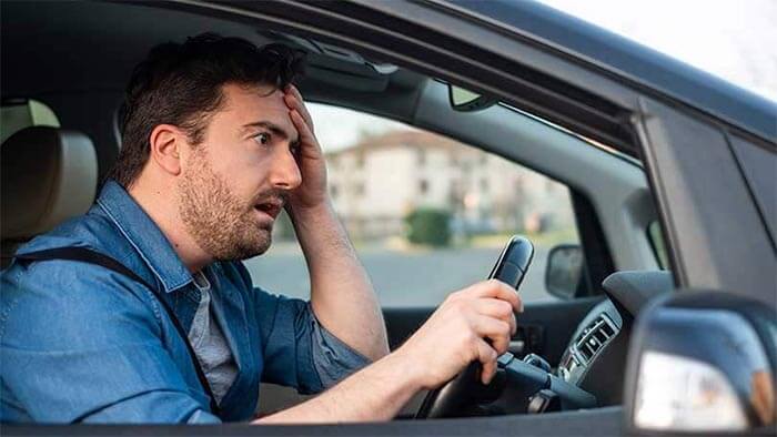 mies ajaa autoaan ja näyttää hämmentyneeltä