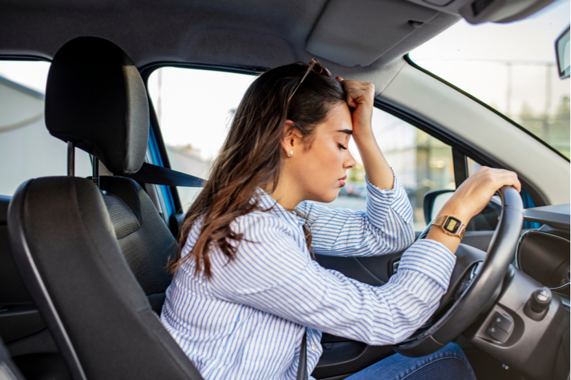 A driver looks unhappy at the wheel of their car