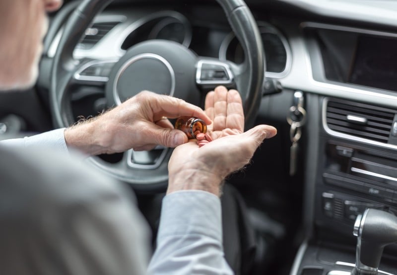 A driver with pills on outstretched hands