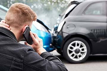 man phoning for help following a car accident