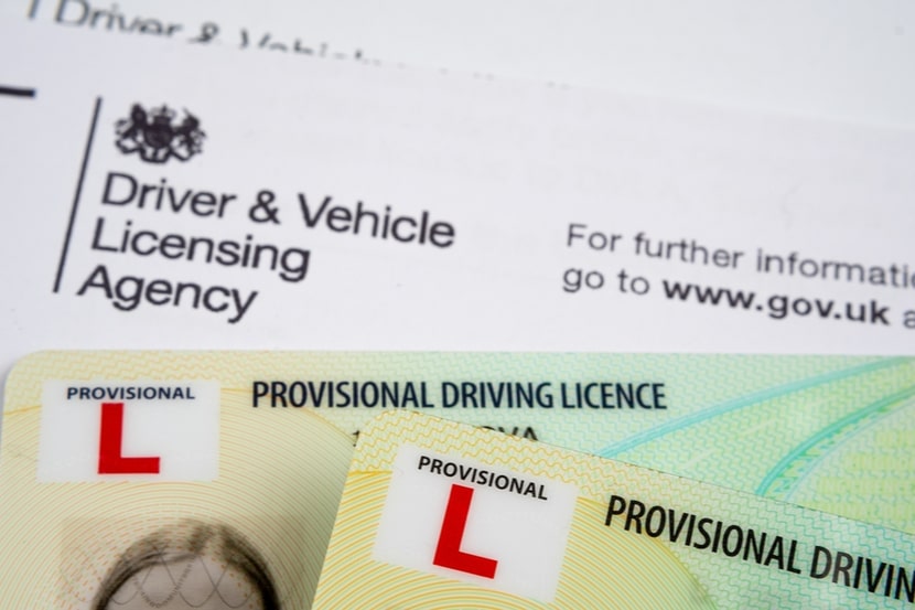 A picture of a provisional licence placed on top of  DVLA form
