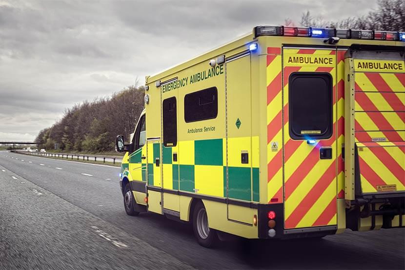 Ambulance with sirens on driving on a carriageway
