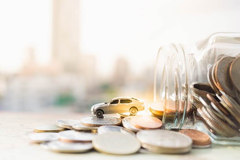 Model car spilling out of a jar of money