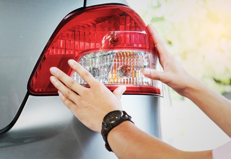 A person checking their car lights ahead of an MOT