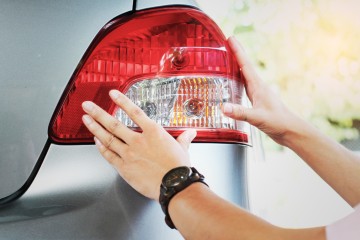 A person checking their car lights ahead of their MOT