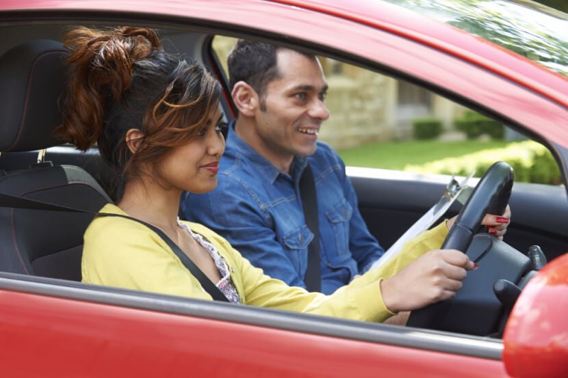 Young woman taking driving test in her own car