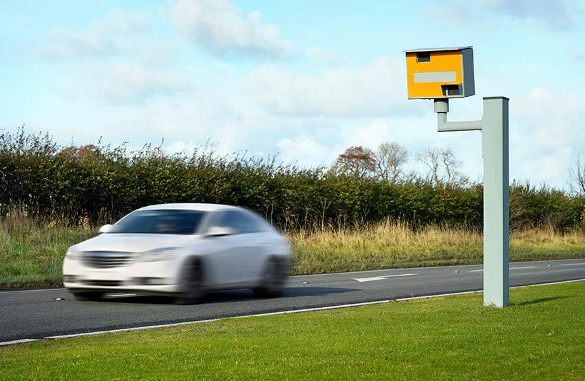 car speeding in the backdrop of a speed camera