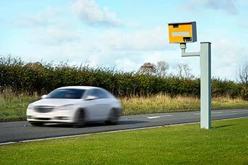 car speeding in the backdrop of a speed camera