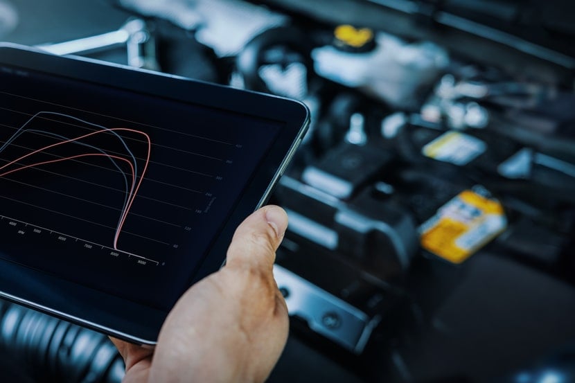 Mechanic using digital tablet to check vehicle performance after chiptuning
