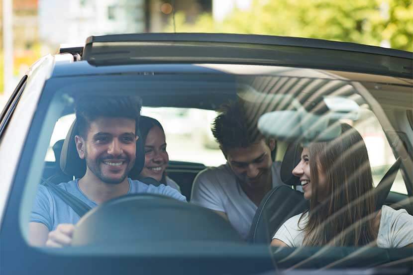 Smiling friends car sharing