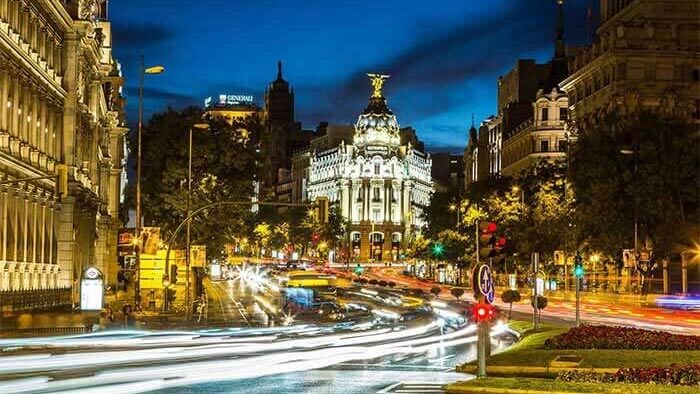 Spanish city road lit up at night with traffic