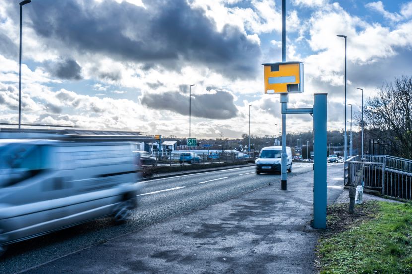 A speed camera with cars quickly passing by