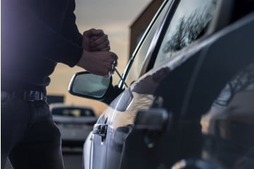 A thief breaking into a car 