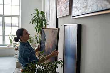 Woman hanging art on a wall
