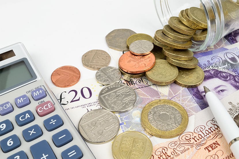 Coins and notes next to a calculator