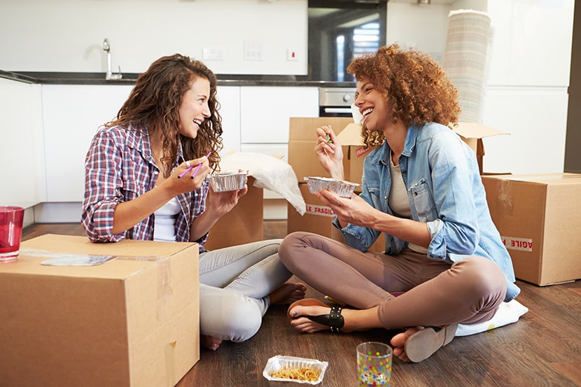 Two students unpacking their boxes and eating takeaway