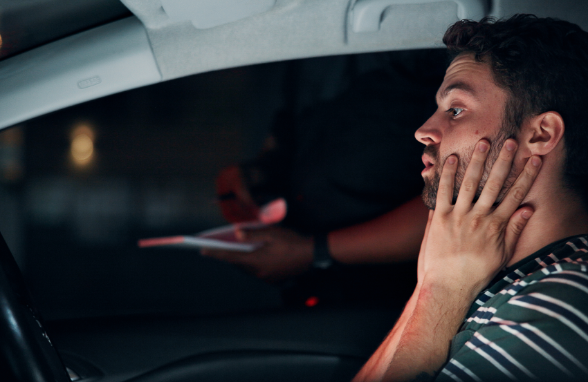 man stressed holding his face while in his car