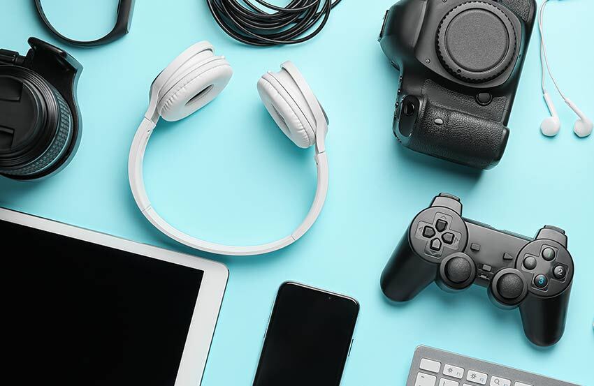 Verious pieces of tech, like headphones and tablets, arranged on a light blue background