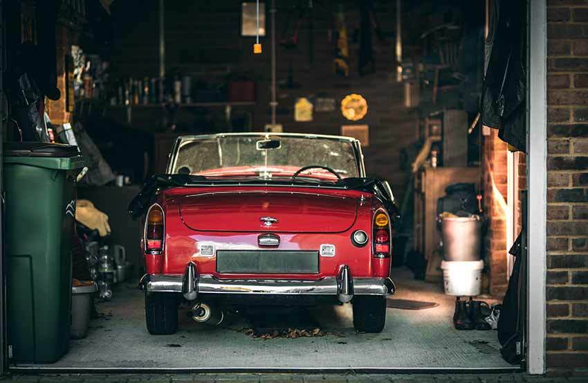 Rear end of a red convertible car parked in a garage